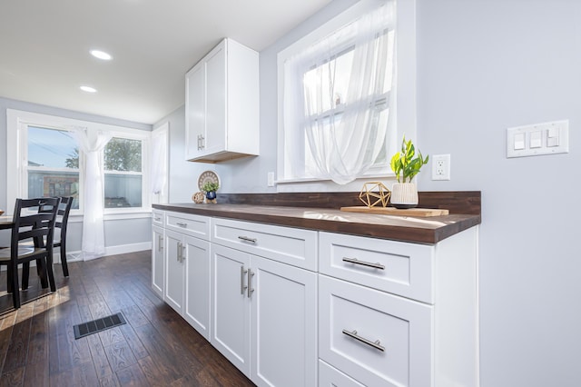 kitchen featuring wood counters, dark hardwood / wood-style flooring, and white cabinets