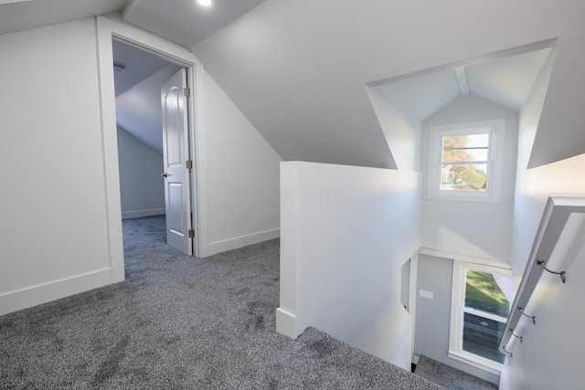 interior space with dark carpet and lofted ceiling