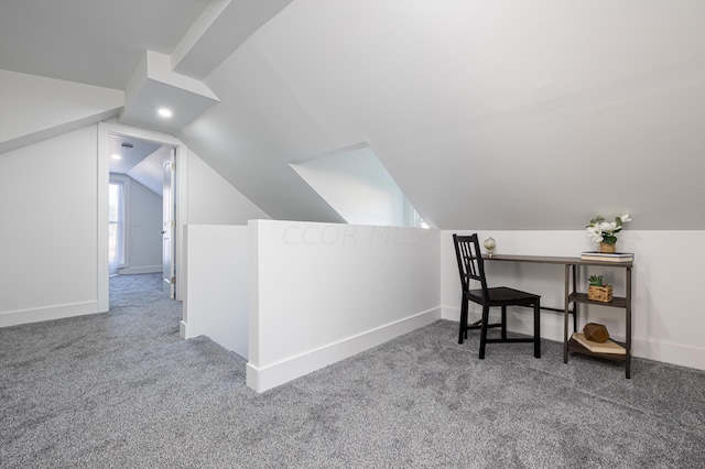 carpeted office featuring lofted ceiling