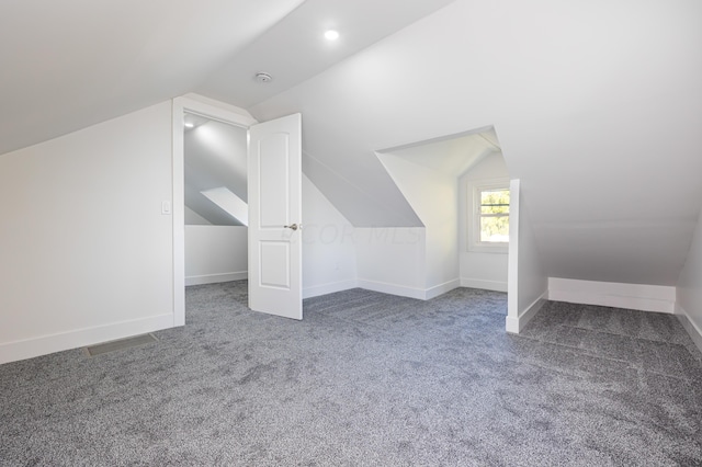 bonus room featuring dark carpet and lofted ceiling