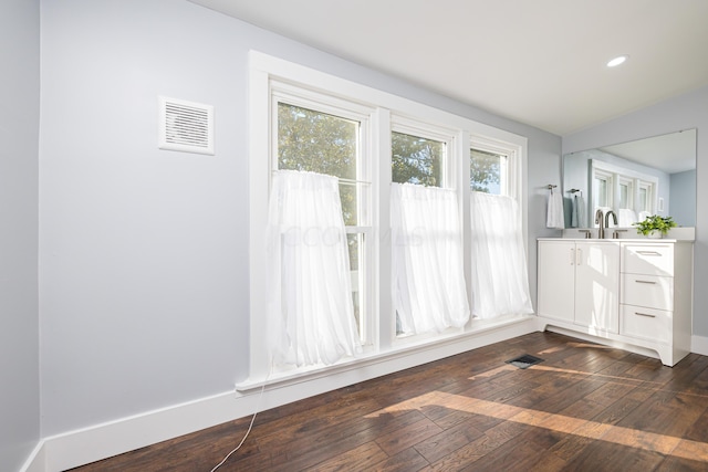 interior space with vanity, hardwood / wood-style flooring, and vaulted ceiling