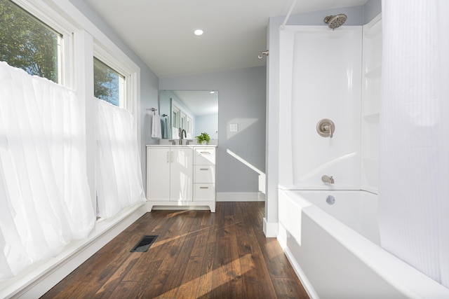 bathroom with shower / bathing tub combination, vanity, wood-type flooring, and vaulted ceiling