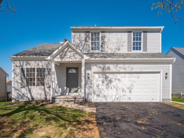 view of front property featuring a garage and a front lawn