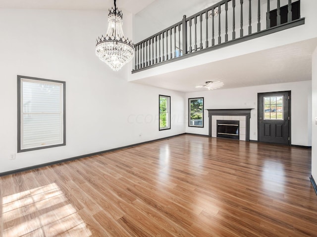 unfurnished living room featuring a high ceiling, plenty of natural light, and hardwood / wood-style floors