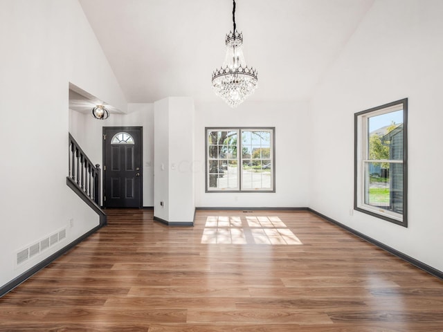 interior space with hardwood / wood-style floors, high vaulted ceiling, and a notable chandelier