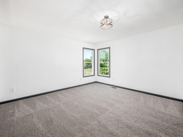 carpeted spare room featuring a textured ceiling