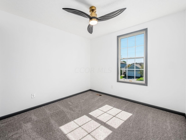 carpeted spare room featuring ceiling fan