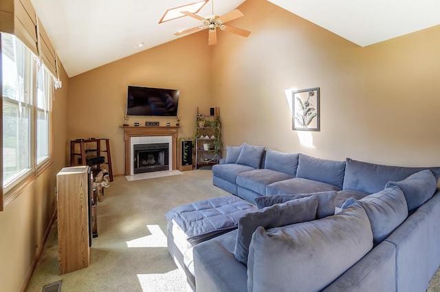 carpeted living room featuring a tile fireplace, ceiling fan, and lofted ceiling