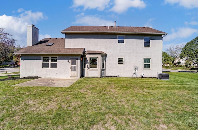 rear view of property featuring a lawn, a patio area, and central AC