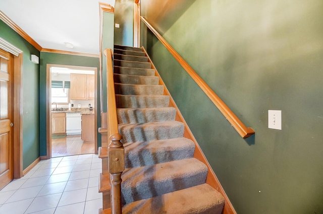 stairway with tile patterned floors, ornamental molding, and sink