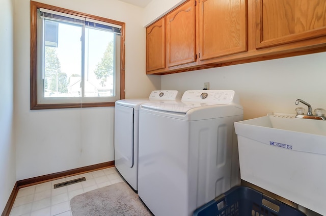 washroom featuring cabinets, sink, and washing machine and clothes dryer