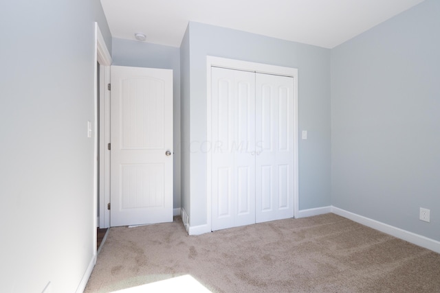 unfurnished bedroom featuring carpet flooring and a closet