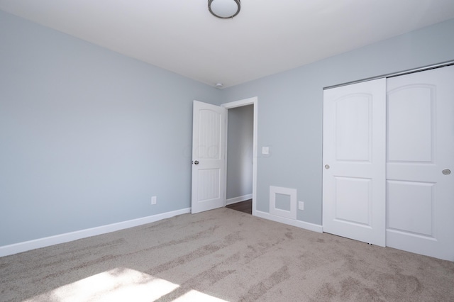 unfurnished bedroom featuring light colored carpet and a closet