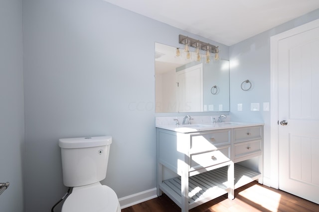 bathroom with hardwood / wood-style floors, vanity, and toilet