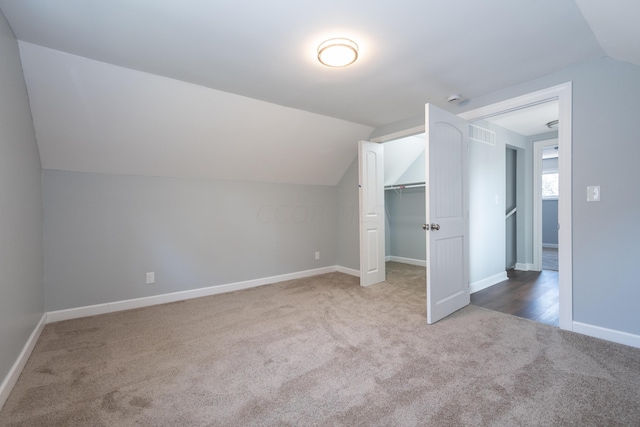 additional living space featuring carpet and lofted ceiling