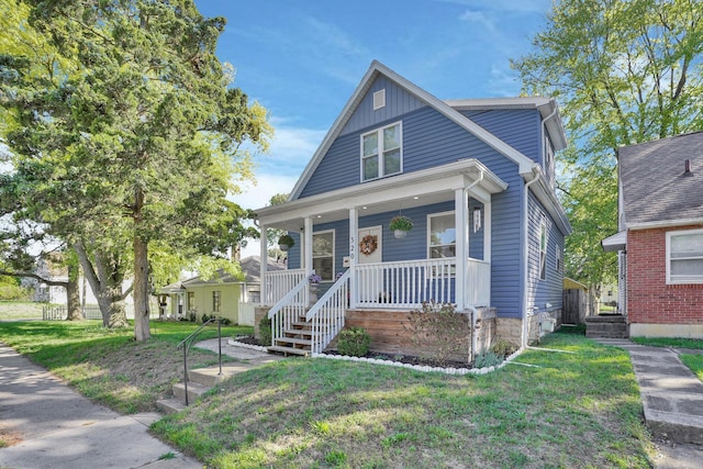 view of front of house with covered porch and a front lawn