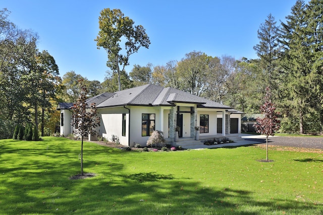 rear view of house featuring a yard and a garage