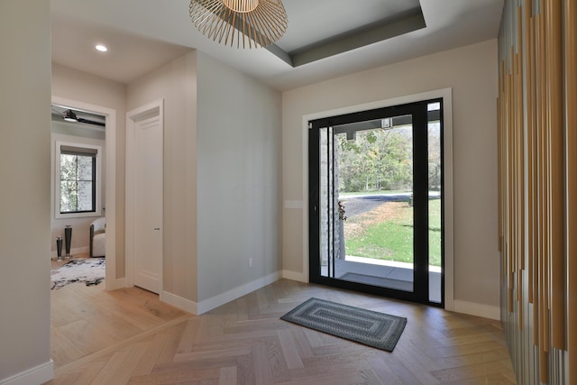 foyer entrance with light parquet flooring, a wealth of natural light, and ceiling fan