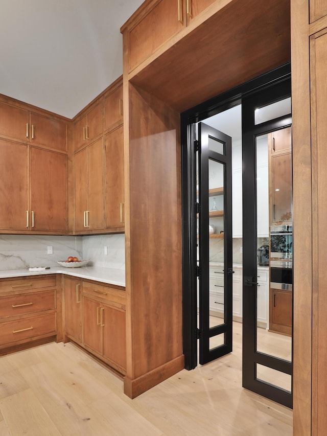 kitchen with decorative backsplash and light hardwood / wood-style flooring