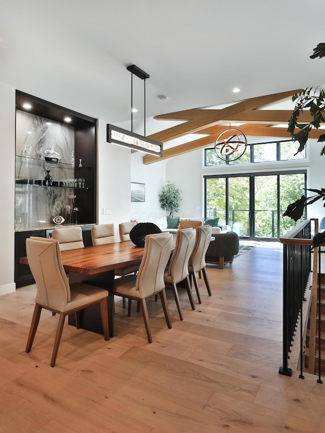 dining room with beamed ceiling and light hardwood / wood-style floors