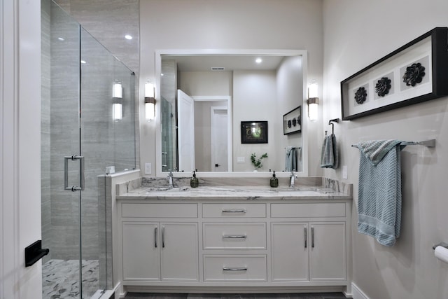 bathroom with vanity and a shower with door