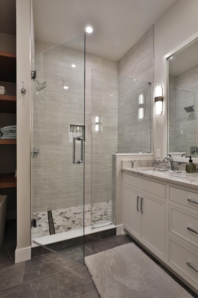 bathroom featuring vanity and a shower with door