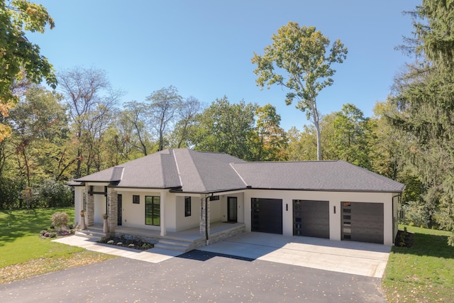 view of front facade with a porch, a garage, and a front yard