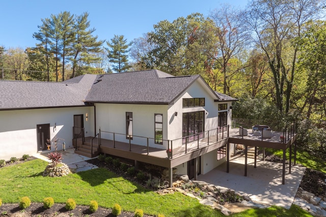 back of house featuring a lawn, a patio area, and a wooden deck