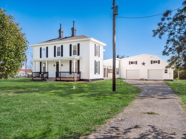 view of front of home with a porch, a garage, an outdoor structure, and a front lawn