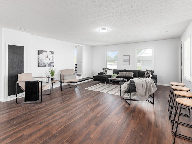 living room featuring dark wood-type flooring and a textured ceiling