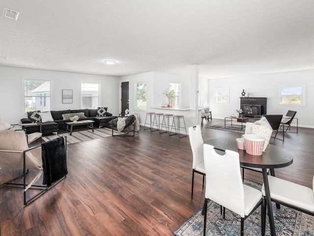 dining room featuring dark wood-type flooring and a textured ceiling