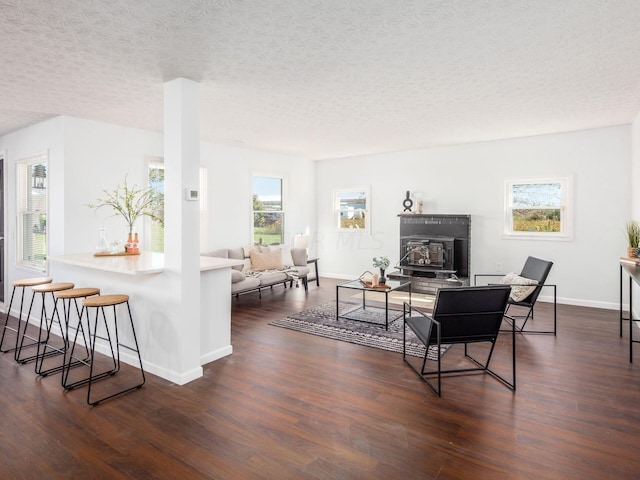 living room with a textured ceiling, dark hardwood / wood-style flooring, and plenty of natural light