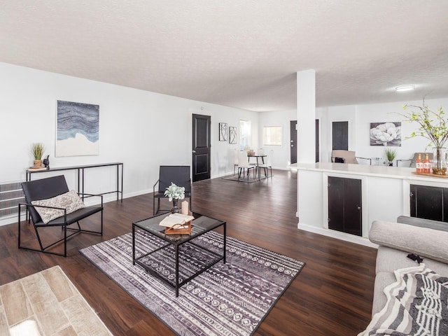 living room with dark wood-type flooring and a textured ceiling