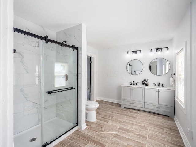 bathroom featuring vanity, toilet, and a shower with door