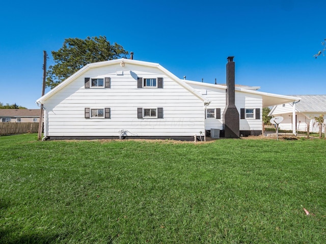 back of property with a yard and central air condition unit