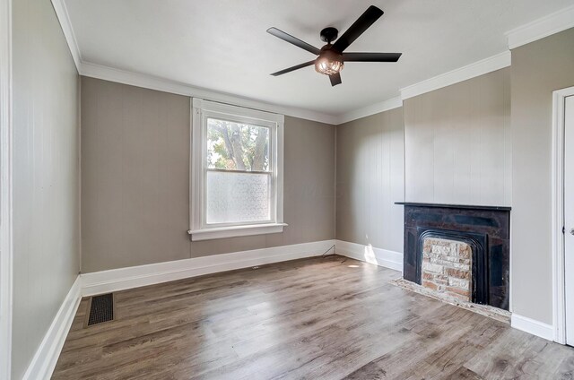 unfurnished living room with hardwood / wood-style flooring, ceiling fan, ornamental molding, and a fireplace