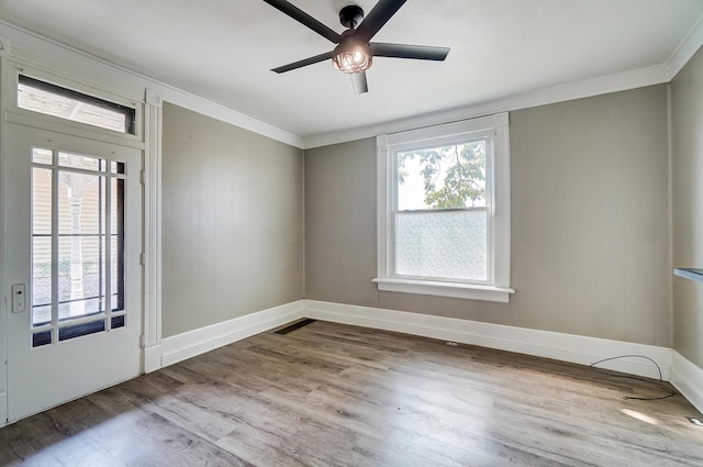 empty room with ceiling fan, light hardwood / wood-style floors, and ornamental molding