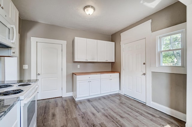 kitchen with white cabinets, light hardwood / wood-style floors, and white appliances