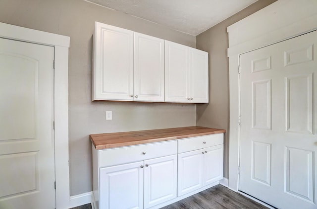 kitchen with white cabinetry, dark wood-type flooring, and wooden counters