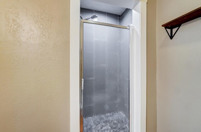 bathroom featuring a shower with door