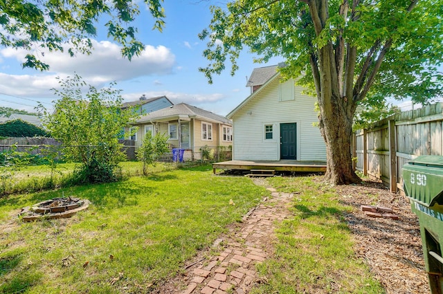 view of yard with a deck and an outdoor fire pit