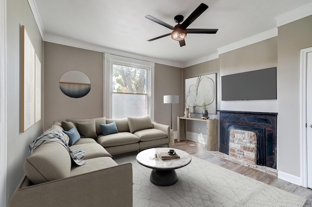 living room featuring light hardwood / wood-style flooring, ceiling fan, and ornamental molding