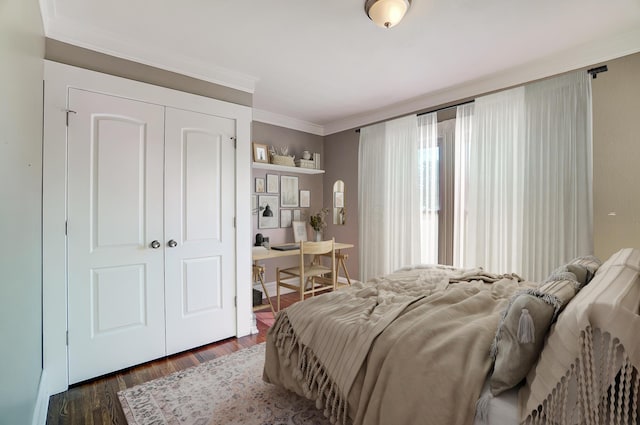 bedroom with dark hardwood / wood-style flooring, a closet, and ornamental molding