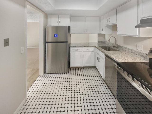 kitchen with light stone counters, stainless steel appliances, exhaust hood, sink, and white cabinets