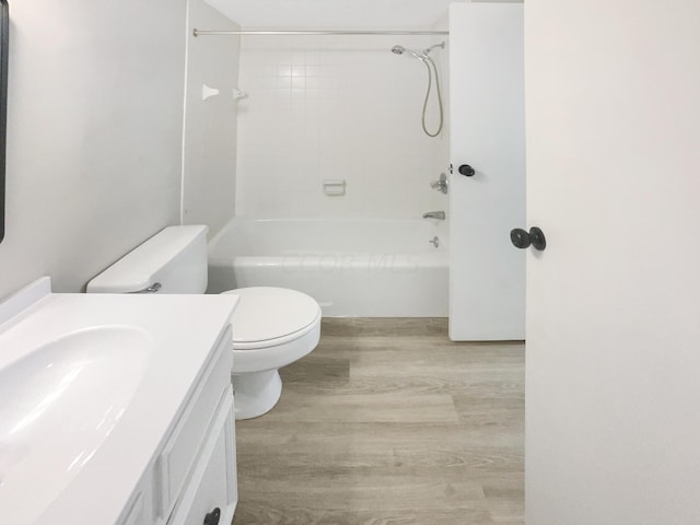 full bathroom featuring wood-type flooring, vanity, toilet, and tiled shower / bath