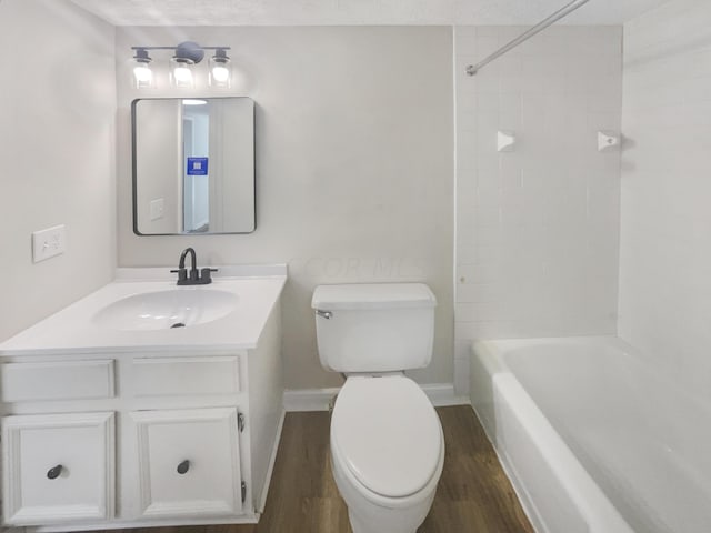 full bathroom with hardwood / wood-style floors, vanity, toilet, and a textured ceiling