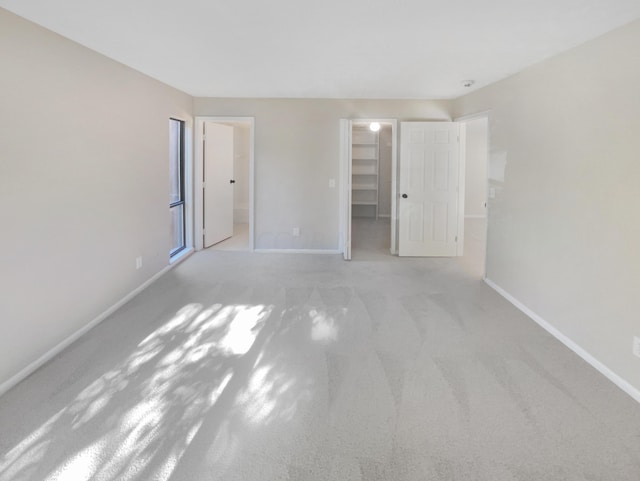 interior space with a spacious closet, a closet, and light colored carpet