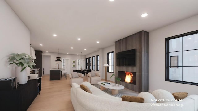 living room featuring a fireplace, light wood-type flooring, and a wealth of natural light