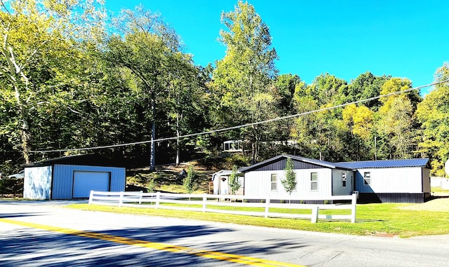 view of front of house featuring an outbuilding, a front lawn, and a garage