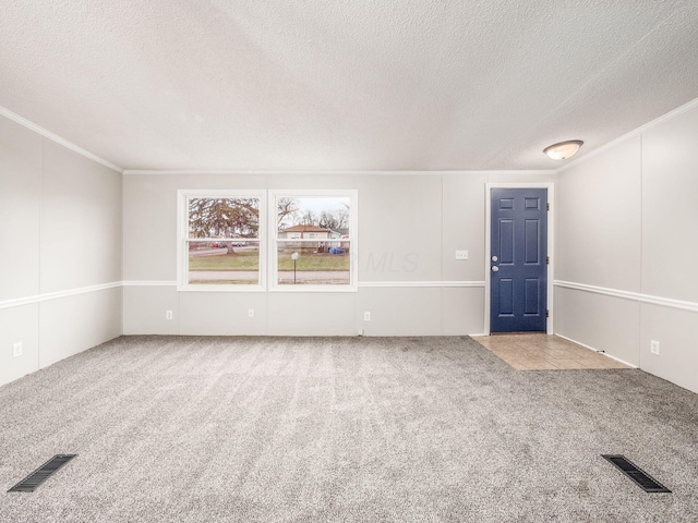 spare room with light carpet, a textured ceiling, and ornamental molding